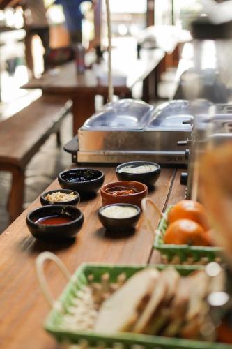a table with bowls of condiments and plates of food at Alaska Patagonia Hostel in San Carlos de Bariloche