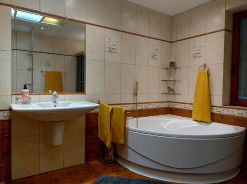 ein Badezimmer mit einer großen Badewanne und einem Waschbecken in der Unterkunft Bungalow 