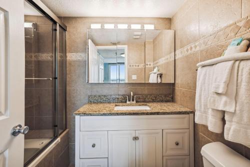 een badkamer met een wastafel, een douche en een spiegel bij Trillium 2B - Premier in St Pete Beach