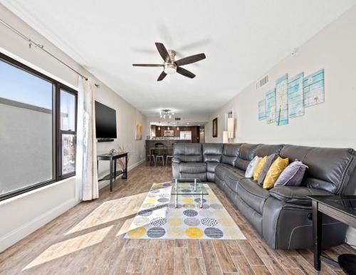 a living room with a leather couch and a ceiling fan at Arie Dam 404 in St. Pete Beach
