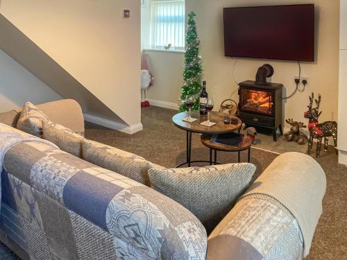a living room with a couch and a fireplace at Low Stonebank Cottage-uk41027 in Hunwick