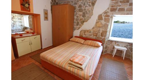 a bedroom with a bed and a stone wall at Lovely Apartment ES in Umag