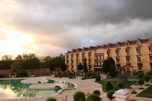 ein großes Gebäude mit Pool davor in der Unterkunft Gabala Yeddi Gozel Hotel in Qəbələ