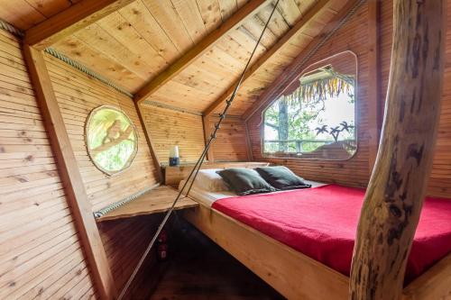 una habitación en una casa del árbol con una cama en ella en Domaine des vaulx en La Baconnière