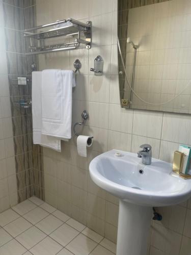 a bathroom with a sink and a mirror and towels at شقق توليب الروضه للشقق المخدومة in Riyadh