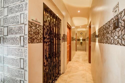 a hallway with a wall of etched glass doors at Hotel Tejasri Residency in Vijayawāda