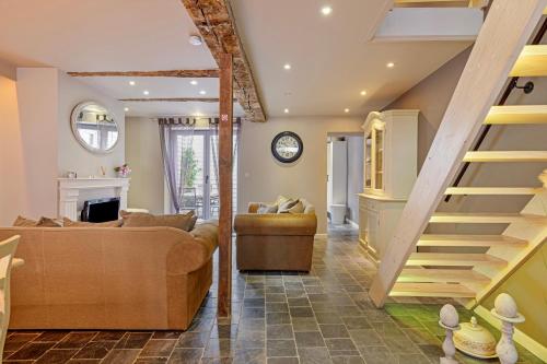 a living room with a couch and a staircase at Bibi Tongeren in Tongeren