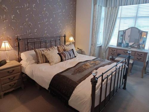 a bedroom with a bed and a dresser and a mirror at 7 Cromwell Gardens - 2 Bed House in Scarborough