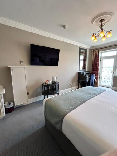 a bedroom with a large bed and a flat screen tv at Lakeside Manor Hotel in Virginia