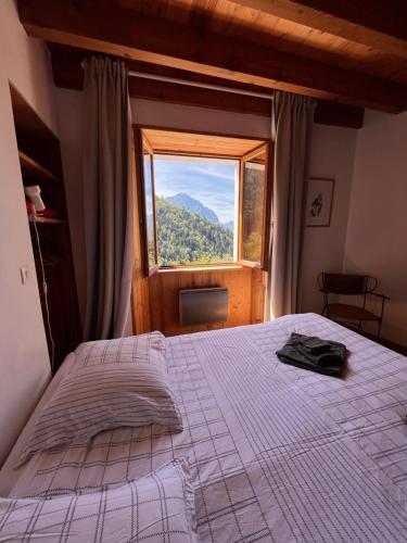 a bedroom with a bed and a large window at Apartment Cascade 3 minutes from Alpe d Huez Grand Domaine via Oz en Oisans in Oz