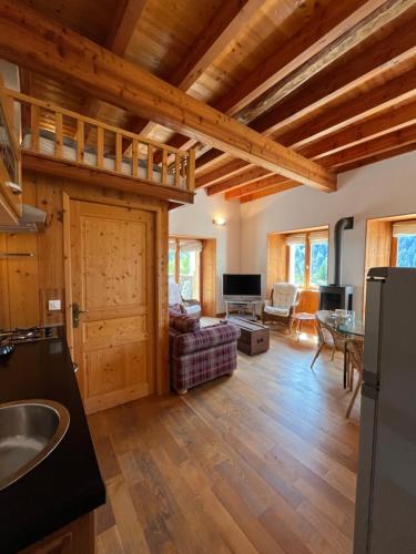 a kitchen and living room with wooden ceilings at Apartment Cascade 3 minutes from Alpe d Huez Grand Domaine via Oz en Oisans in Oz