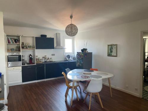 a kitchen with a table and chairs in a room at Appartement chaleureux au cœur de la ville in Saintes