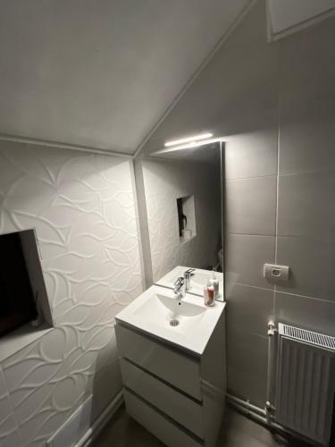 a white bathroom with a sink and a mirror at Pensiunea Sarah - Muntele Mic in Muntele Mic