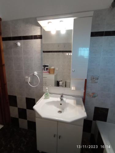 a bathroom with a sink and a mirror at Επικούρεια Κατοικία in Gorgogýrion