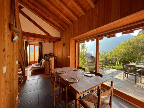 une salle à manger avec une table et une grande fenêtre dans l'établissement Apartment Belledonne 3 minutes from Alpe d Huez Grand Domaine via Oz en Oisans, à Oz