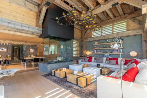 a living room with wooden ceilings and a chandelier at Chalet Le Nolde in Mussillon