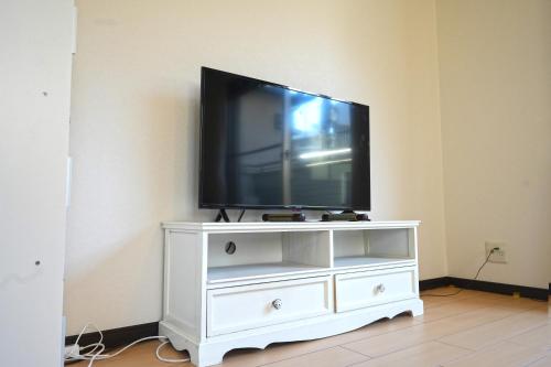 a tv sitting on a white entertainment center at Maple Hotel Osaka in Osaka
