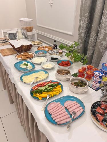 a table with plates of meats and vegetables on it at Dworek Dębicki in Dębica