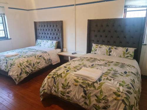 1 dormitorio con 2 camas, cabecero y cama sidx sidx sidx sidx sidx sidx en HASATE GUEST HOUSE 13 LOUWVILLE STREET BELLIVILLE Cape Town south Africa, en Ciudad del Cabo