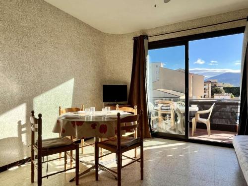 une salle à manger avec une table et des chaises et un balcon dans l'établissement Argelès-sur-Mer : Studio cabine avec terrasse, proche plage et commerces, parfait pour famille - FR-1-225-637, à Argelès-sur-Mer