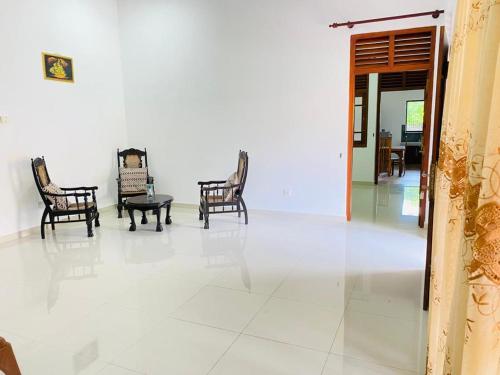 a room with chairs and a table on a tile floor at White Villa in Weligama