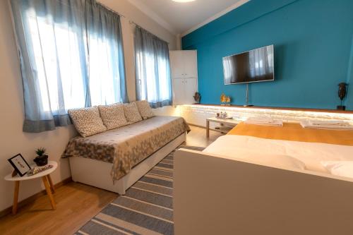 a bedroom with a bed and a couch and a tv at Korte Apartment 1 in Arta