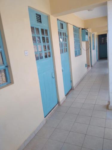 a hallway with blue doors on a building at VILLA DE LEO in Bungoma