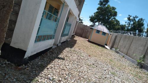 einen Zaun neben einem Haus mit Garten in der Unterkunft VILLA DE LEO in Bungoma