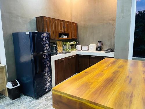 a kitchen with a black refrigerator and wooden cabinets at New View Hikkaduwa in Hikkaduwa