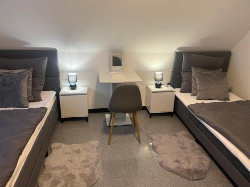 a room with two beds with a desk and a chair at Apartment by Harbali in Schüttorf