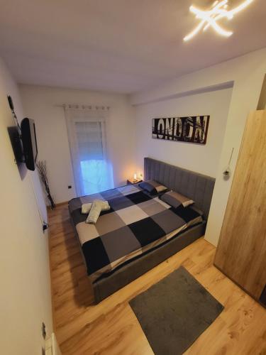a bedroom with a bed with a checkered blanket at Apartman TARA in Zagreb