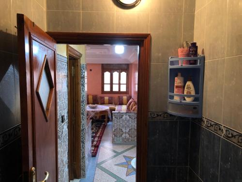 a room with a door open to a kitchen with a refrigerator at Zino house in Khouribga