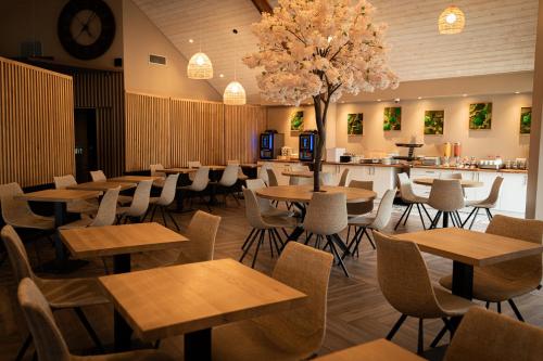 a restaurant with tables and chairs and a bar at Logis Clermotel - Hôtel & Restaurant in Agnetz