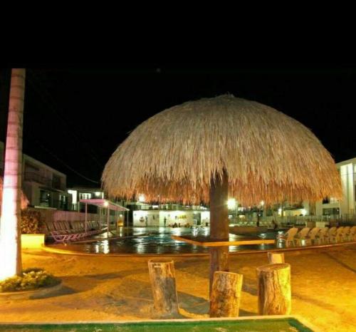 a large straw umbrella in front of a building at Apartamento vista piscina principal in Santa Fe de Antioquia
