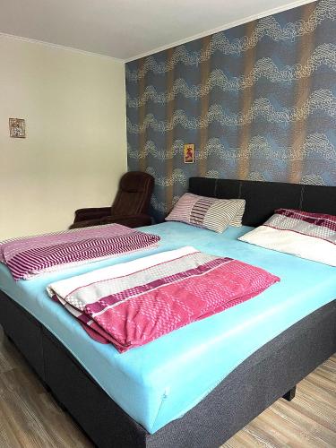 1 dormitorio con 1 cama grande con sábanas rosas y azules en Gemütliche Oase en Fürth