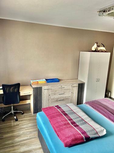 Schlafzimmer mit einem Schreibtisch, einem Bett und einem Stuhl in der Unterkunft Gemütliche Oase in Fürth