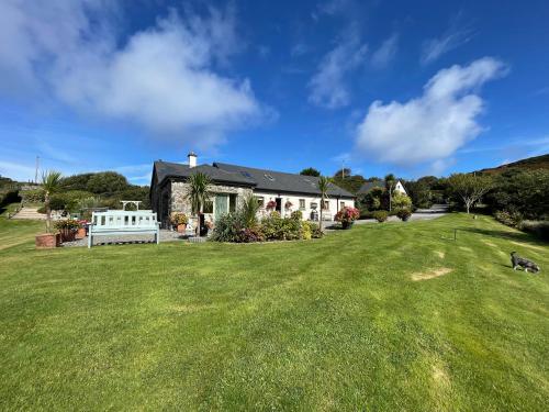 a house with a large lawn in front of it at The Garden Room at Sleepy Hollow in Louisburgh