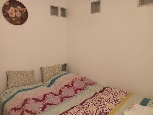 1 dormitorio con 1 cama y reloj en la pared en Meerdaal Vakantie Studio, en Haasrode