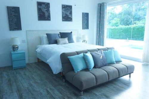 1 dormitorio con 1 cama grande y 1 sofá en CoaSea Pool Villa - 3 Bedrooms 3.5 Bathrooms en Chumphon