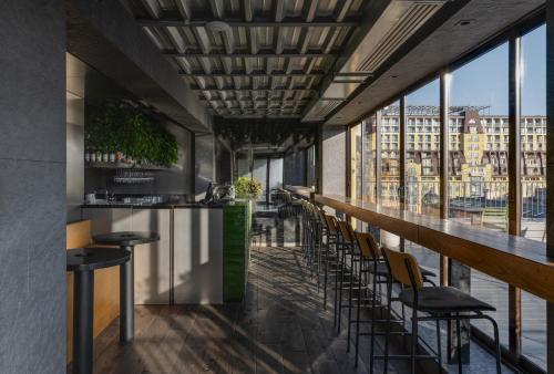 a bar with chairs and a view of a city at BURSA Hotel Kyiv in Kyiv
