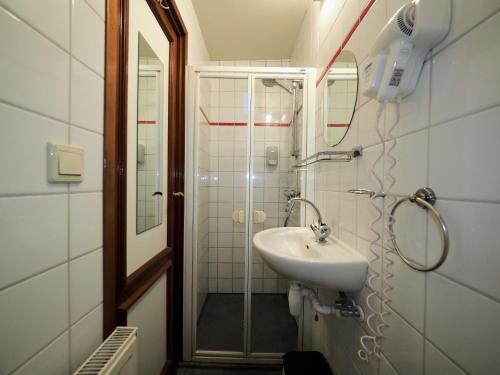 y baño con lavabo y ducha. en hotelboat Sarah Groningen, en Groninga