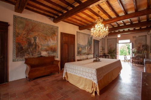 - une chambre avec un lit et un lustre dans l'établissement Villa Cairoli Gonzaga, à Gonzaga