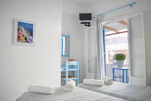 a white bedroom with a bed and a window at Kostas Teacher Apartment in Antiparos