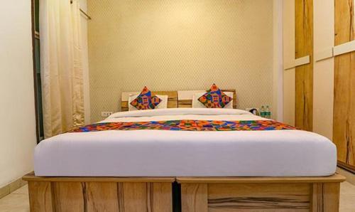 a bedroom with a large bed with a wooden platform at FabHotel The Royal Oak in Gurgaon