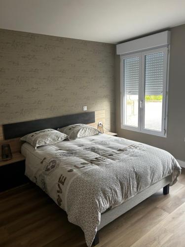 a bedroom with a large bed and a window at Petite maison in Plouguerneau