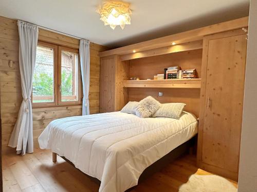 une chambre avec un lit dans une pièce en bois dans l'établissement Charmant T3 au cœur de Samoëns avec jardin, parking et proche ski-bus - FR-1-624-16, à Samoëns