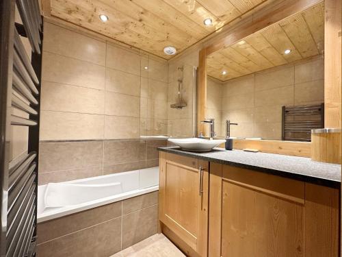 une salle de bain avec un lavabo et une baignoire dans l'établissement Charmant T3 au cœur de Samoëns avec jardin, parking et proche ski-bus - FR-1-624-16, à Samoëns