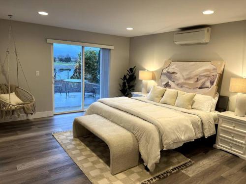 ein Schlafzimmer mit einem großen Bett und einem Balkon in der Unterkunft Your Magnificent Riverfront Home in Woodland
