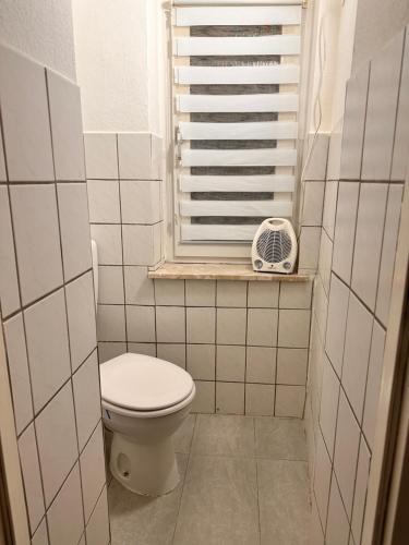 Elle comprend une petite salle de bains pourvue de toilettes et d'une fenêtre. dans l'établissement Geräumige Wohnung Dortmund City, à Dortmund