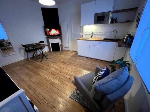 uma sala de estar com um sofá e uma lareira na cozinha em Studio 3 - Mi-Côte - Studio à Orvault em Orvault